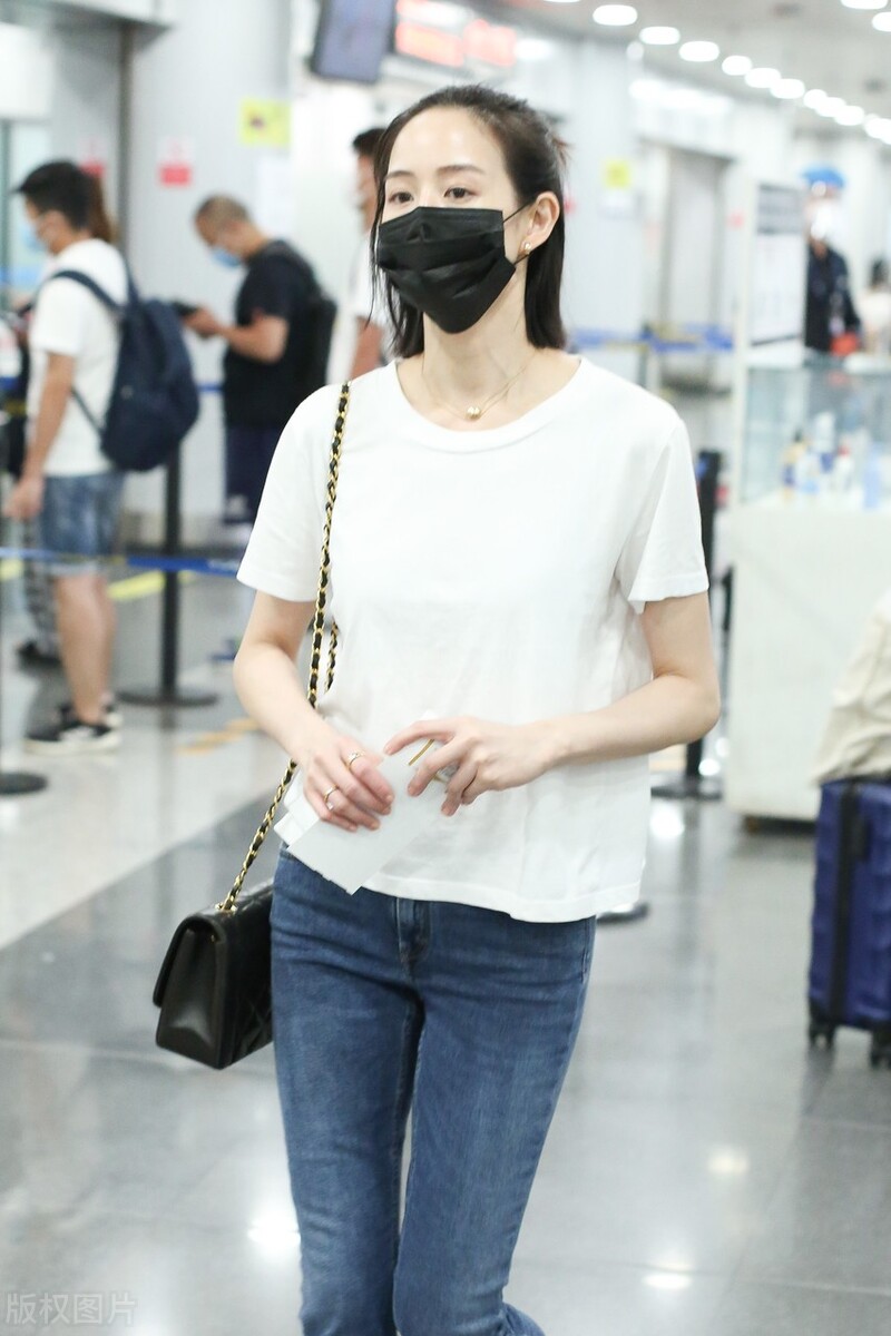 张钧甯戴黑色口罩,穿白色t恤搭配牛仔裤,脚踩平底鞋,休闲随性|张钧甯