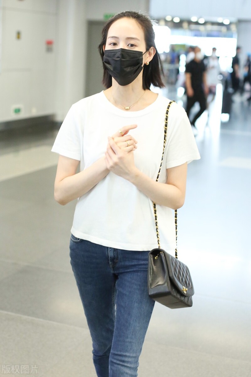 张钧甯戴黑色口罩,穿白色t恤搭配牛仔裤,脚踩平底鞋,休闲随性|张钧甯