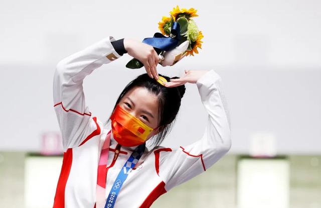 杨倩在领奖台上比心庆祝夺冠图丨icphoto