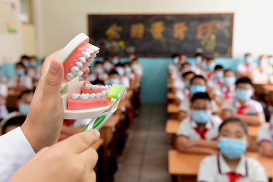 2020年9月18日,河北省石家庄新乐市实验小学,新乐市医院口腔医生指导学生学习正确的刷牙方法。 视觉中国供图