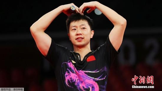 资料图：7月30日晚，东京奥运会乒乓球男单决赛迎来中国选手“内战”。最终马龙以4：2战胜樊振东，成功卫冕冠军。这是中国代表团在本届奥运会的第19金。图为赛后马龙比出心形姿势。
