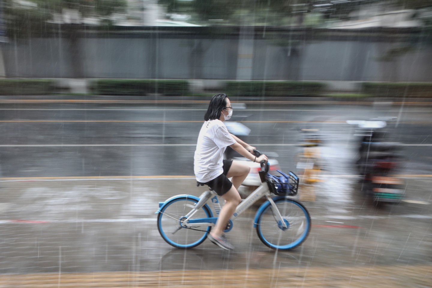 2021年8月,北京突降阵雨,一女士淋雨骑行.新京报记者 王嘉宁 摄 
