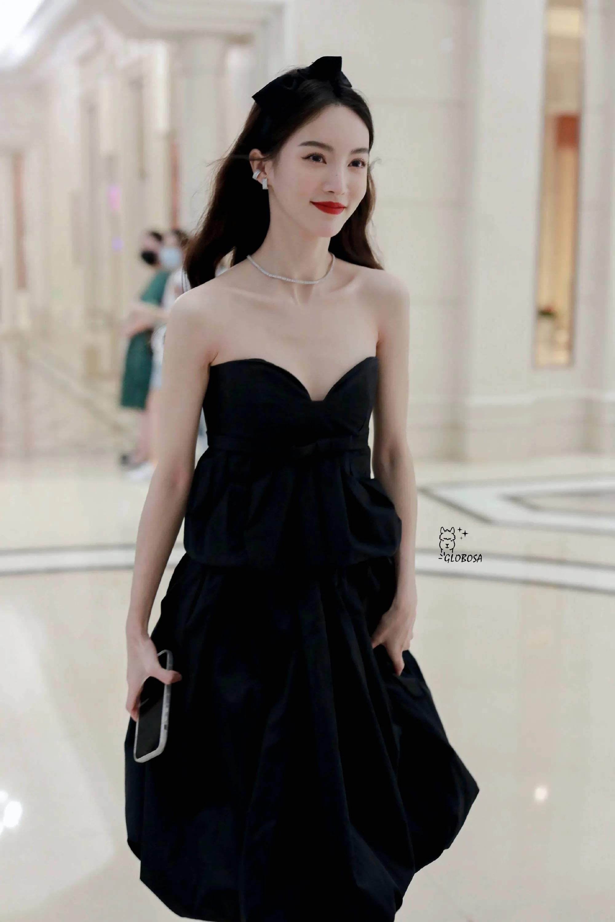 金晨一袭黑色礼裙出席,卷发红唇,配上珍珠项链,黑色蝴蝶结发饰