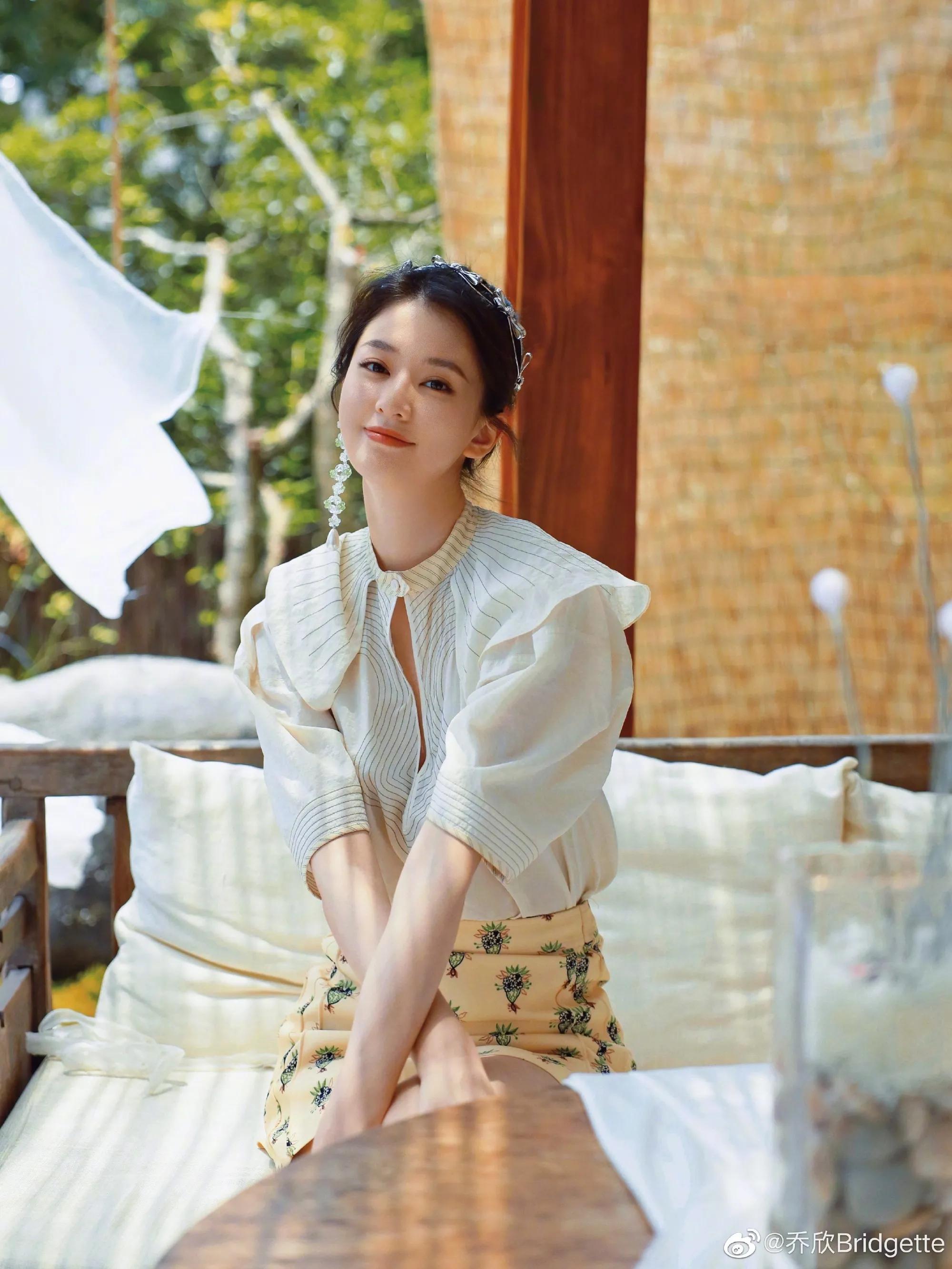 乔欣娃娃领衬衫搭配黄色印花半裙蝴蝶结发饰,精致而甜美