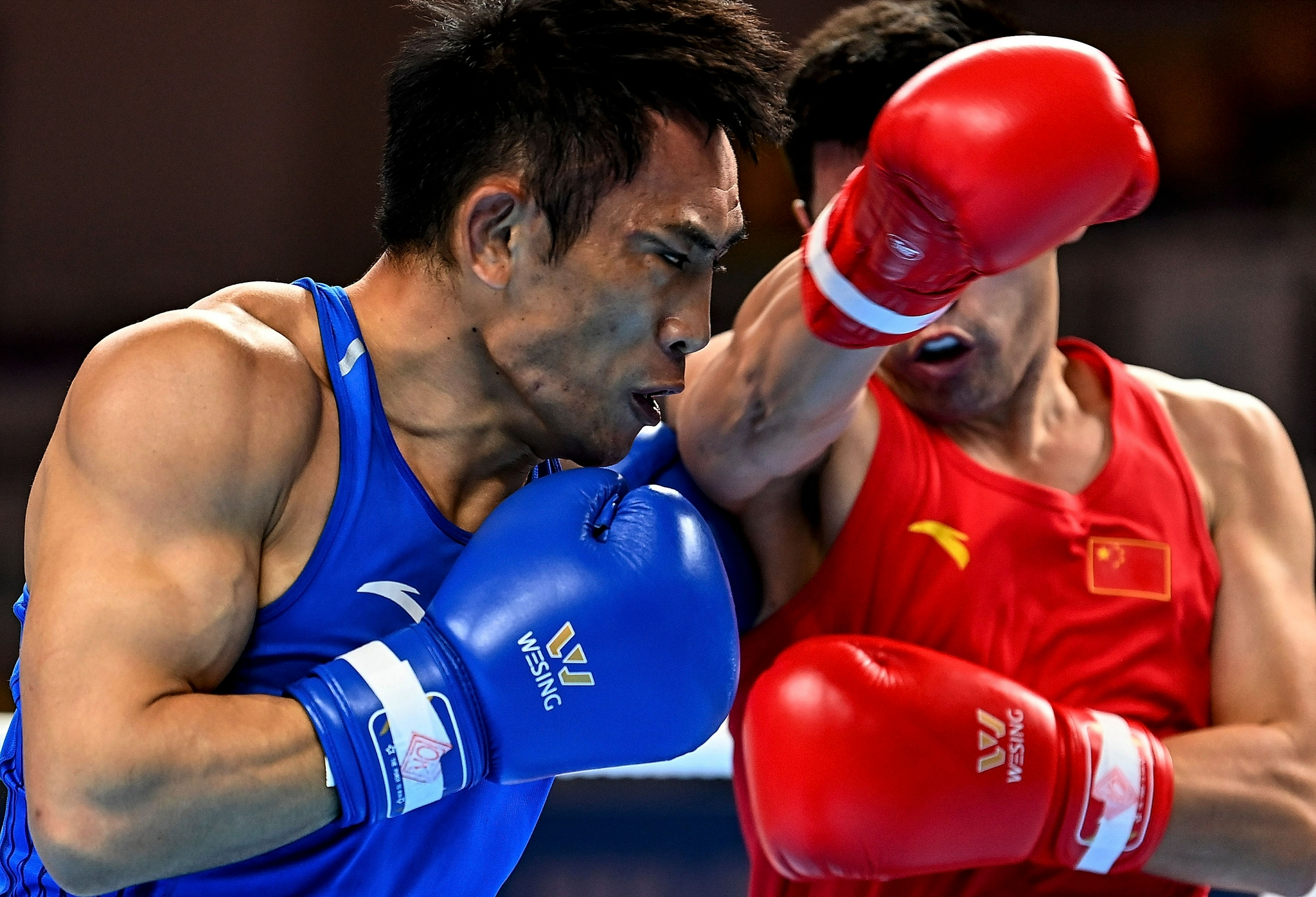 9月16日,湖北队拳手刘伟(左)与陕西队拳手赛日克·托了吾塔衣在比赛