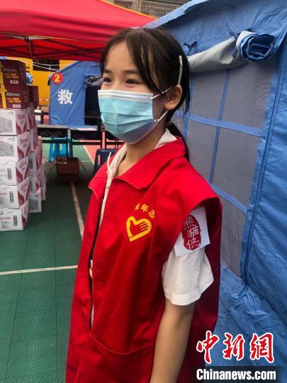 何怡娴的左臂贴有“熊猫侠”贴纸，这是四川500余万名青年志愿者的统一标识。　贺劭清 摄