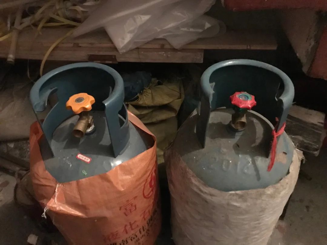 9月13日，李小中购买用来自杀的两个煤气罐被弃放在楼道里。新京报记者 聂辉 摄