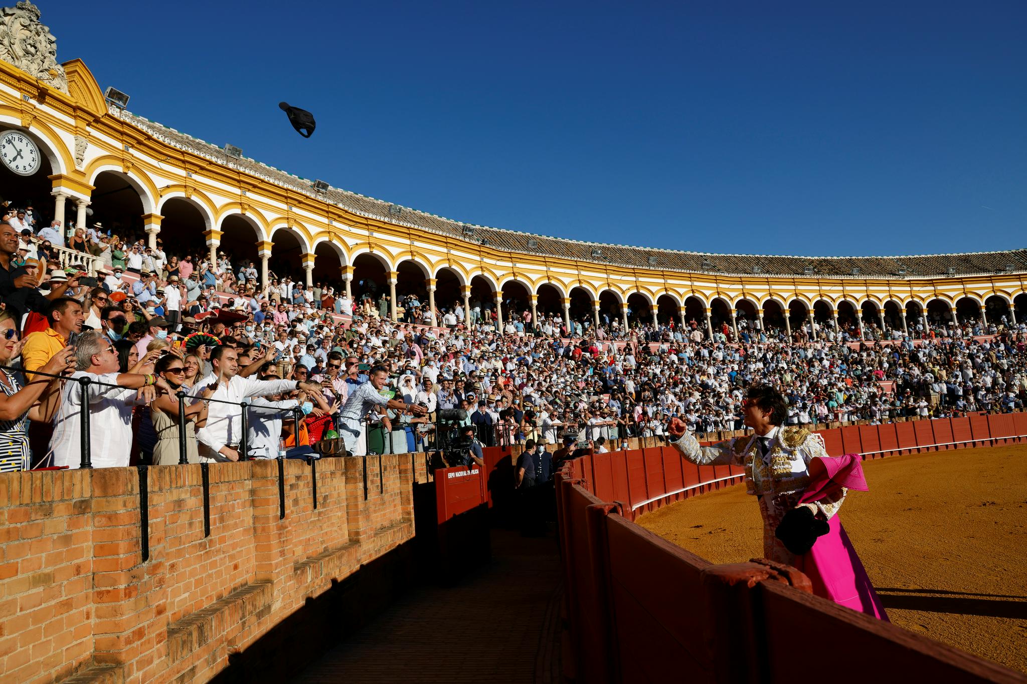 9月18日,斗牛士在西班牙塞维利亚表演斗牛时与观众互动.