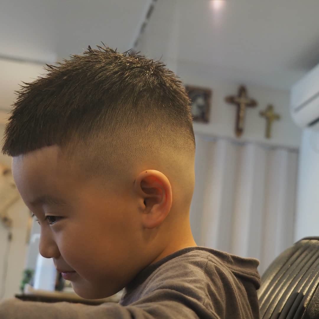 小男孩发型最常见的就是短碎发造型,两侧和后区用电推剪推短,向上逐渐
