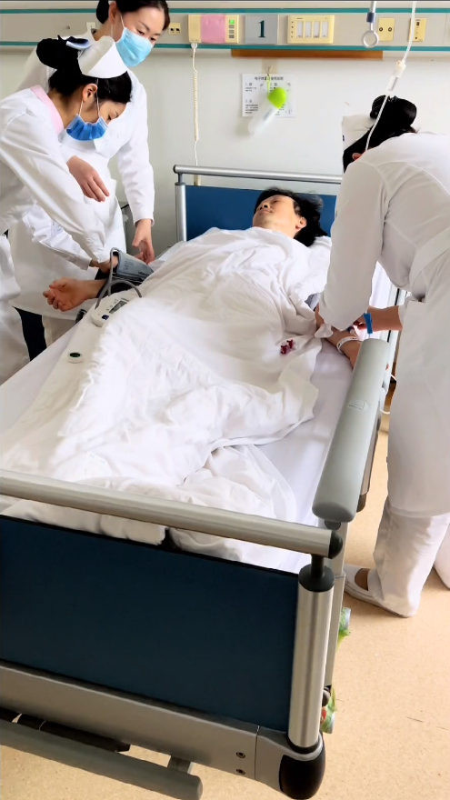 视频中,现年46岁的主持人李彬穿着病号服躺在病床上,身边有几名医护