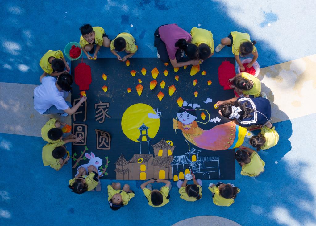 2021年9月17日，孩子们和老师一起制作中秋贴纸画“月圆家圆”（无人机照片）。新华社记者 徐昱 摄