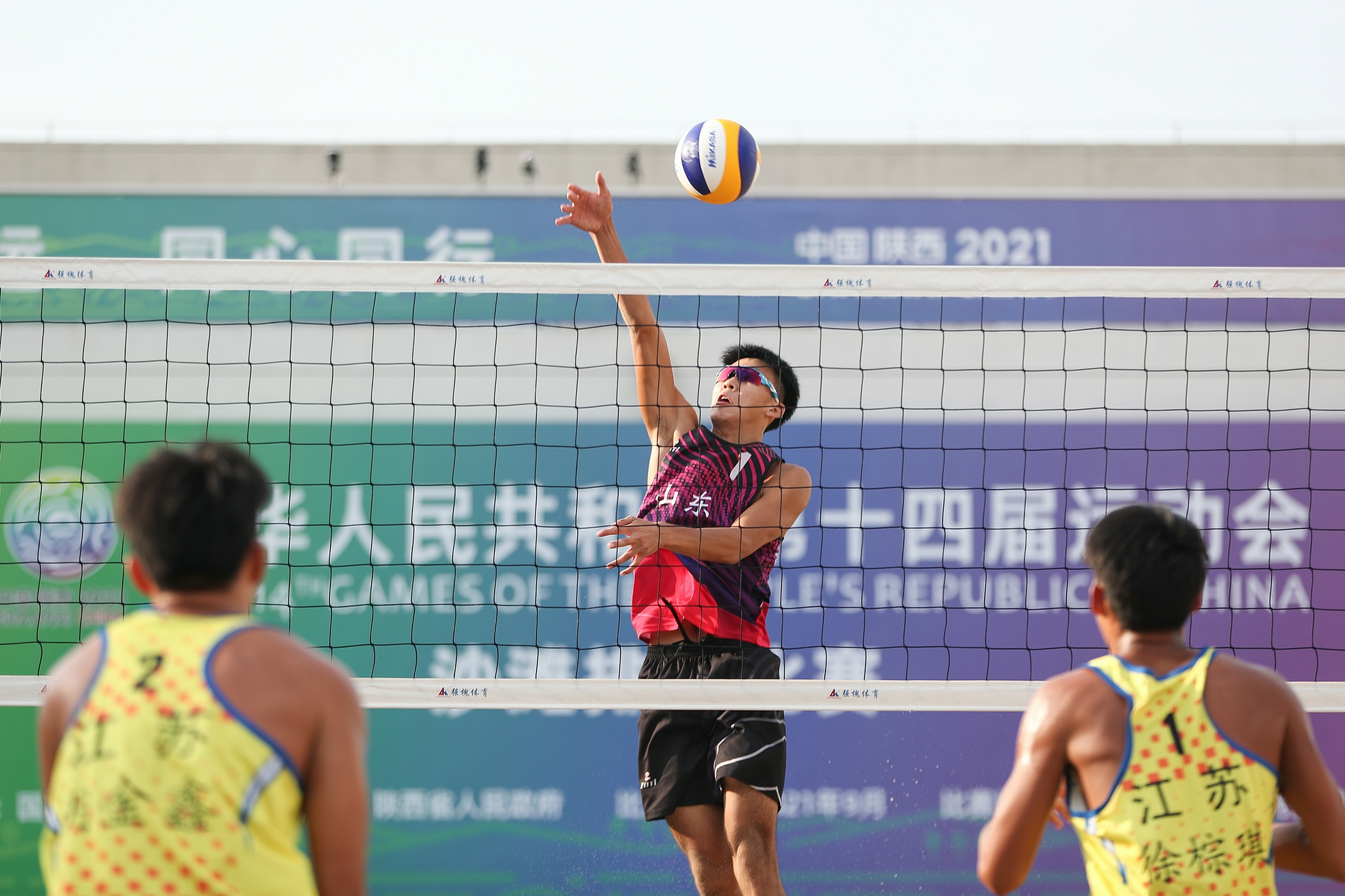 9月22日,山东青年一队球员王志合(中)在比赛中扣球.