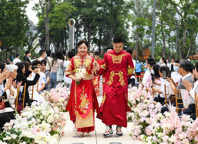 5月20日，在成都高新区桂溪生态公园婚姻登记处，新人们携手走进集体婚礼颁证仪式现场。新华社