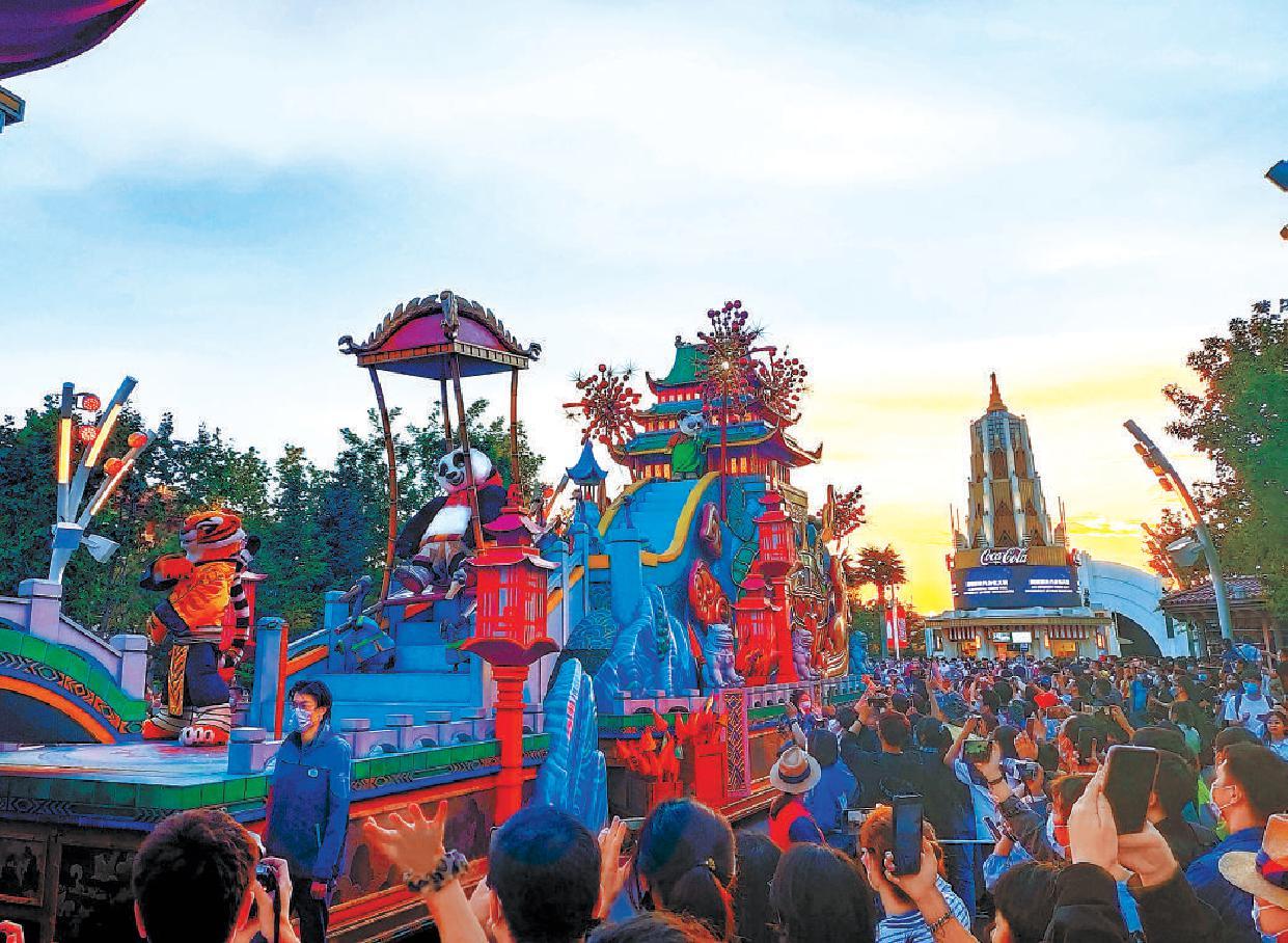 (9月21日,在北京环球影城主题公园,游客与演员亲切互动.