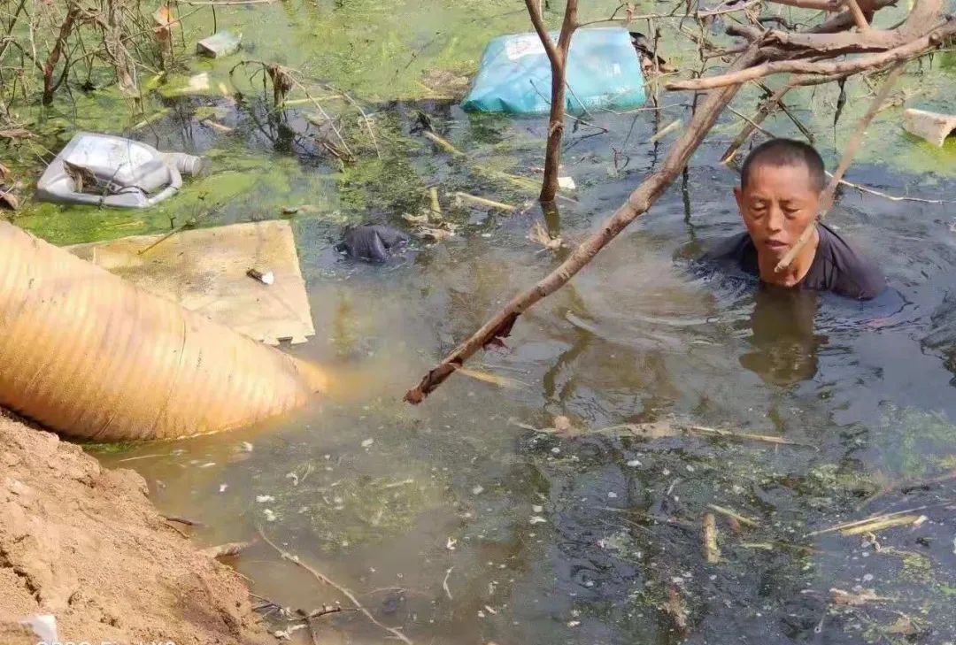 菠萝救援队队员下污水清理水泵口垃圾（图源：受访者供图）