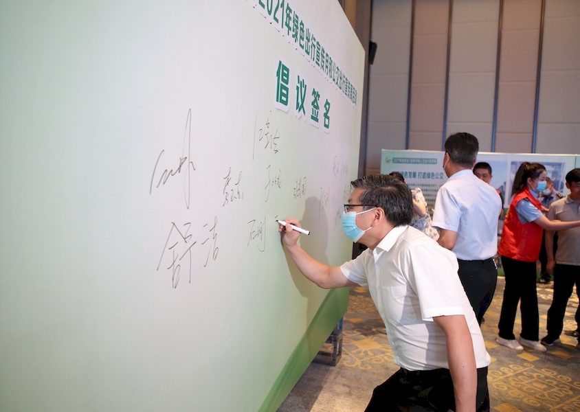 与会人员在"倡导绿色出行,促进生态文明"签名板上签名承诺.何小报摄
