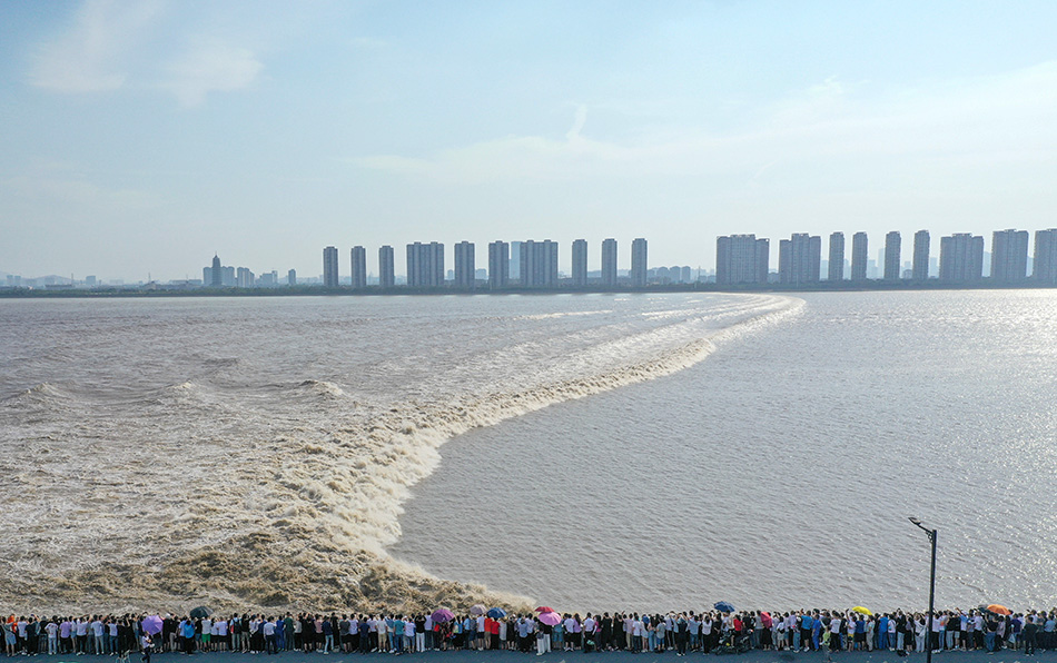 在杭州下沙江堤上，众多市民和游客争睹钱江大潮的壮观景象。
