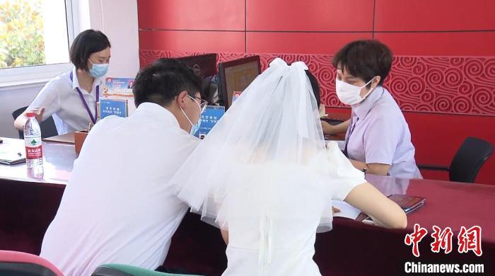 资料图：穿着婚纱登记结婚的新人。 杨季峰 摄