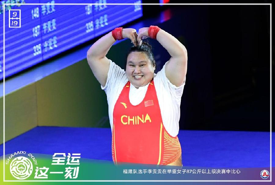 海报：9月19日，福建队选手李雯雯在举重女子87公斤以上级决赛中比心。新华社记者贝赫摄。制图：李莹