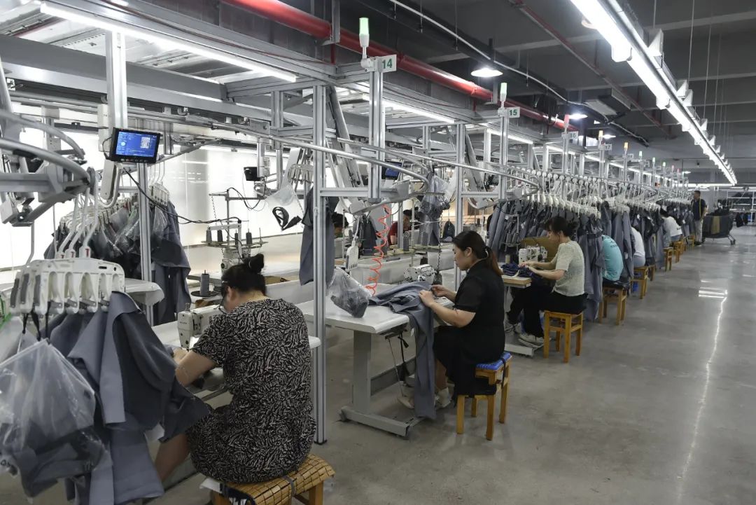 绍兴一服饰公司的生产车间,工作人员在加装了智能吊挂系统的流水线上