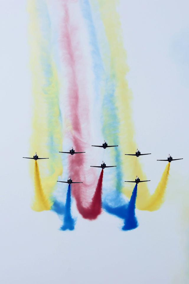 "红鹰"飞行表演队在空中拖出长长的彩色烟雾.