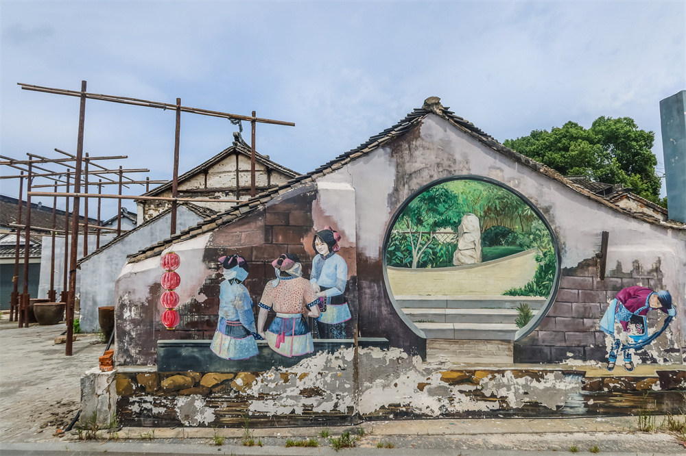 传统服饰墙绘现今古镇女性早已不需要再穿这样的服饰下田农作,不过