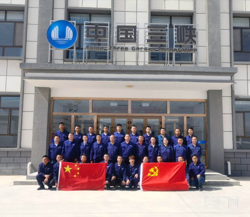 在海南藏族自治州光伏园区,三峡能源光伏电站工作人员与党旗,国旗合影