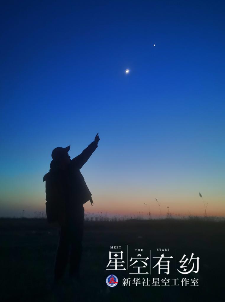 ↑天津市南开中学天文社社员张诣扬2020年3月28日在天津静海区团泊湖拍摄的“金星伴月”。（本人供图）