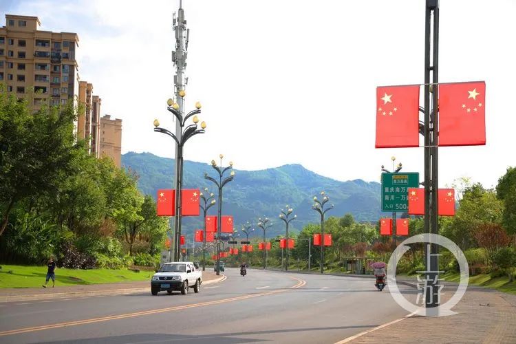 万盛经开区西城大道新悬挂的国旗鲜艳夺目.