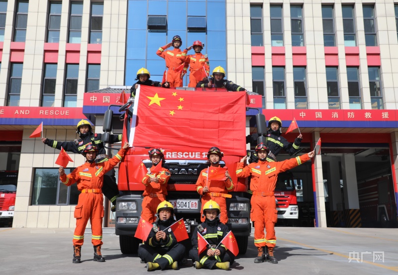 西宁市城东消防救援大队消防员与国旗合影(央广网发 西宁市城东区委