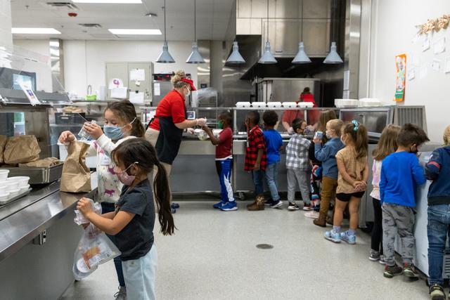 美国一所学校学生在领取饭菜 图自美媒