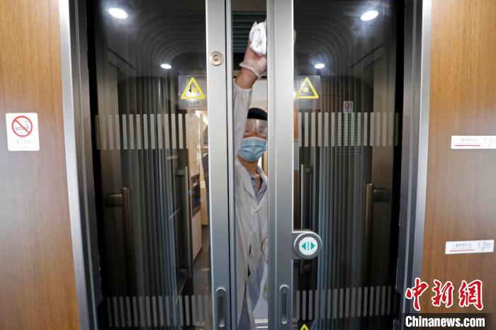 董国生正在对车厢连接处进行消毒. 殷立勤 摄