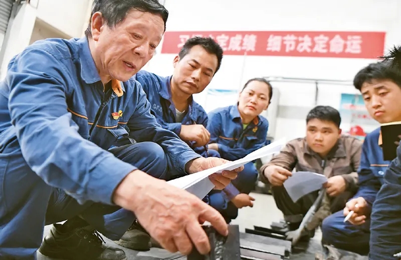 　　图为2021年6月17日，艾爱国（左一）在湖南湘潭湘钢高级技工学校焊接实习基地检查学生的焊接作业。新华社记者 薛宇舸/摄