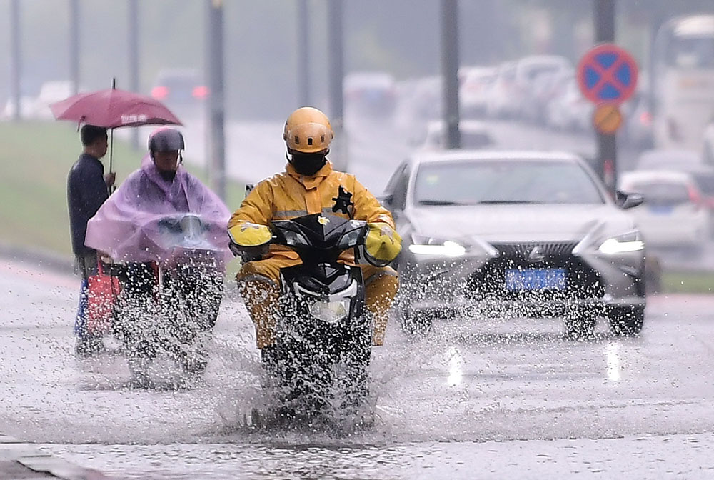 2021年10月3日,沈阳遭遇暴雨天气,市民冒雨出行.视觉中国(14.260,0.