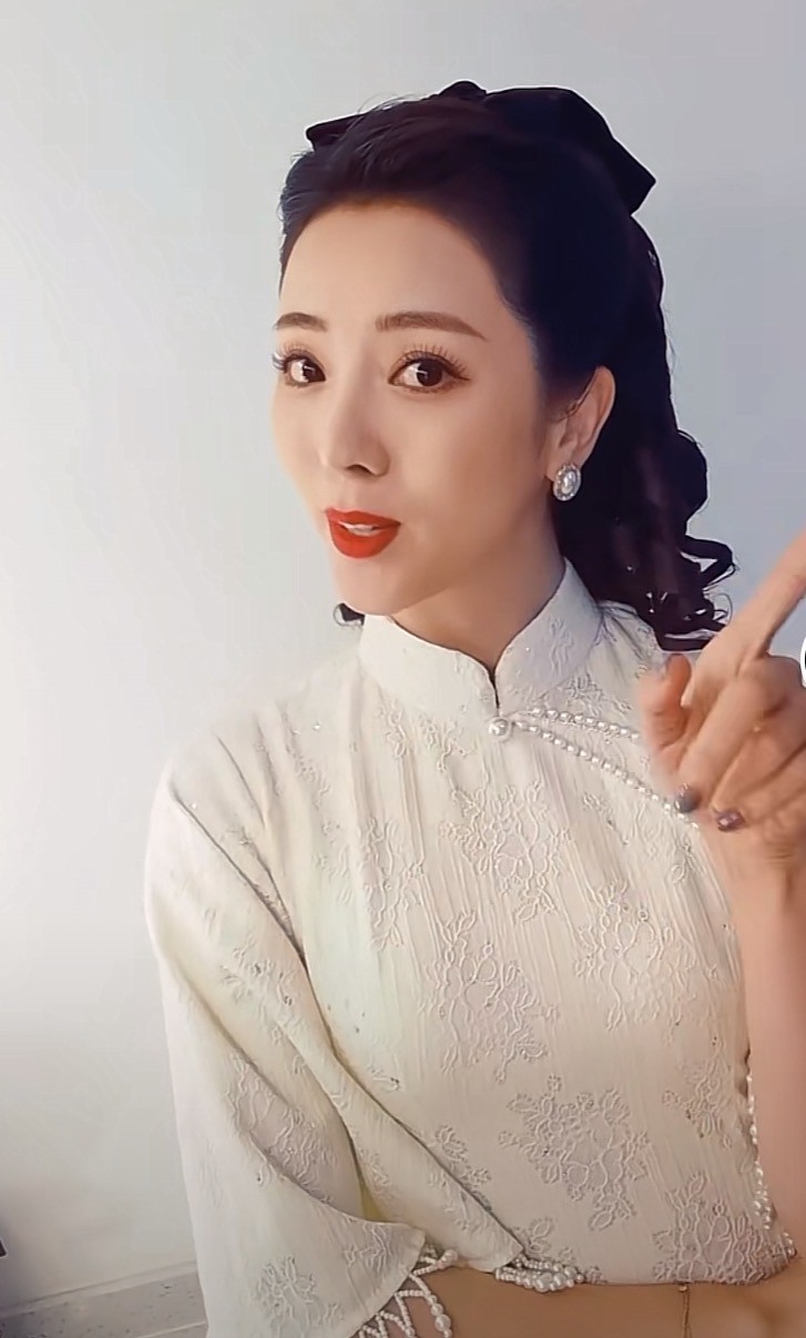 李思思穿珍珠旗袍跳舞鼻子高挺睫毛浓密头戴蝴蝶结对镜头比心
