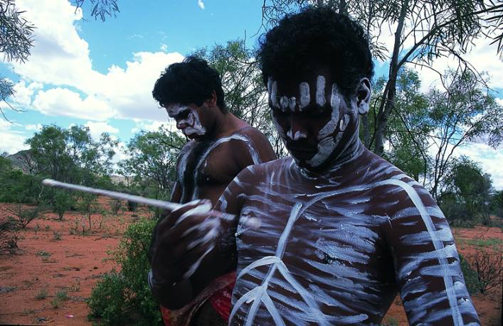 在跳舞前涂绘油彩的原住民青年（2000年2月于澳洲中部爱利斯泉附近沙漠边缘地区，李公明摄）