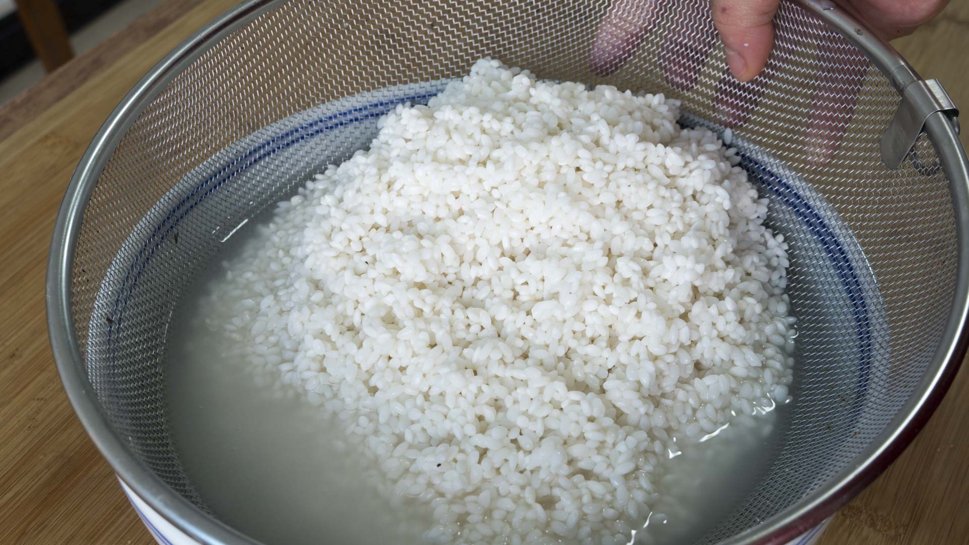 6,接着把泡好的糯米倒出来控干水分;5,接着准备一个洋葱和适量香菇