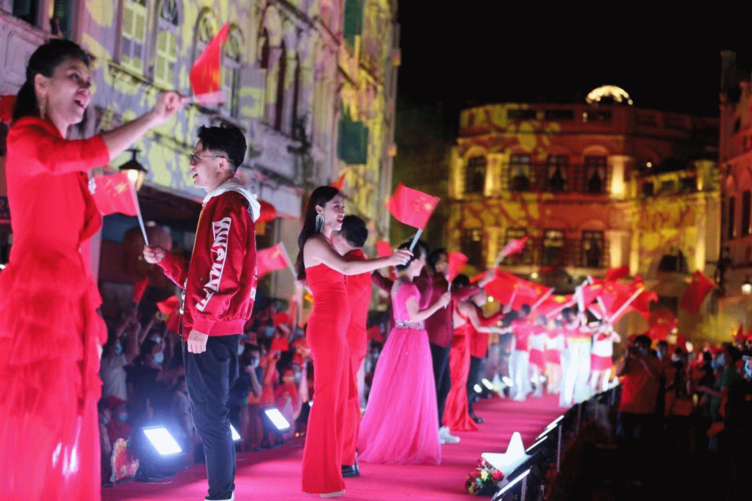 △市民游客在骑楼老街游景区、赏美景、看演艺、品美食，街道上处处红旗飘扬，很是热闹。