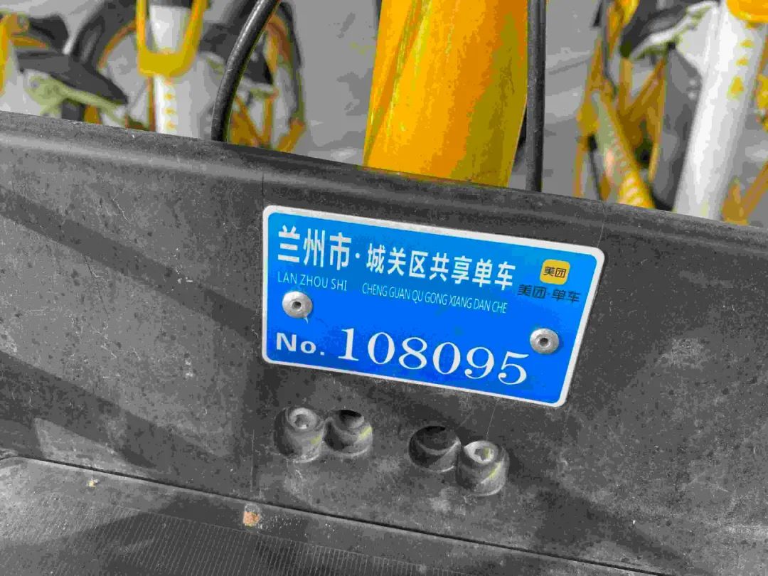 现场一名工作人员正在为共享单车安装车牌.