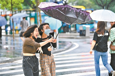 昨日下班时分,天河商圈风大雨大,女孩手里的伞被吹翻了.