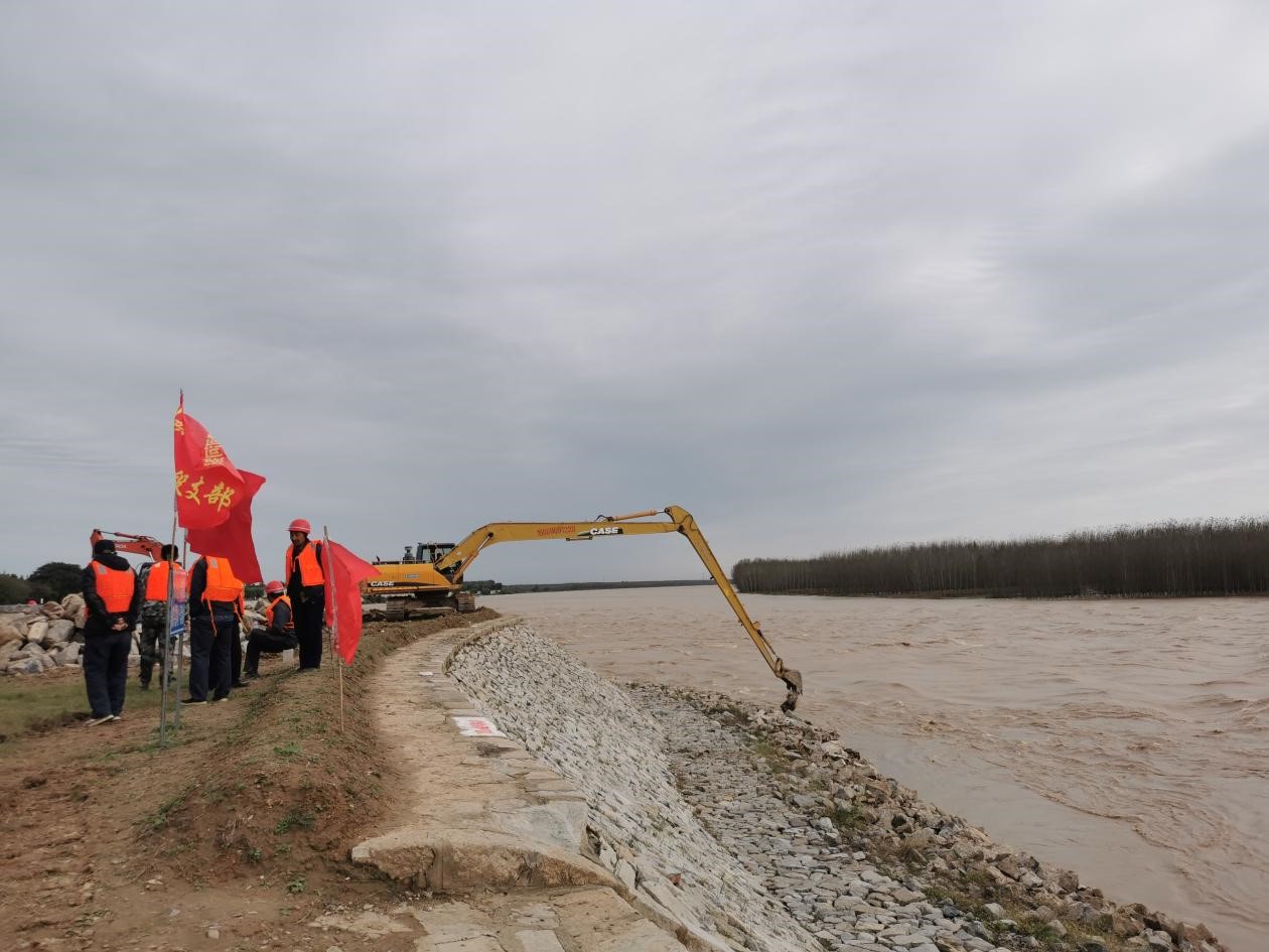 长臂挖掘机正在进行加固河堤的施工作业