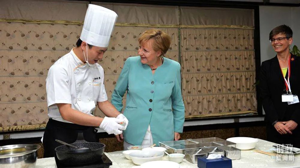 △2014年7月，默克尔总理曾专程到访四川成都。这是她正在观摩大厨做宫保鸡丁，对川菜表现出巨大热情。（资料图）