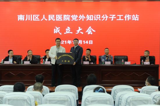 图为南川区委常委,统战部部长毛朝银为党外知识分子工作站授牌.