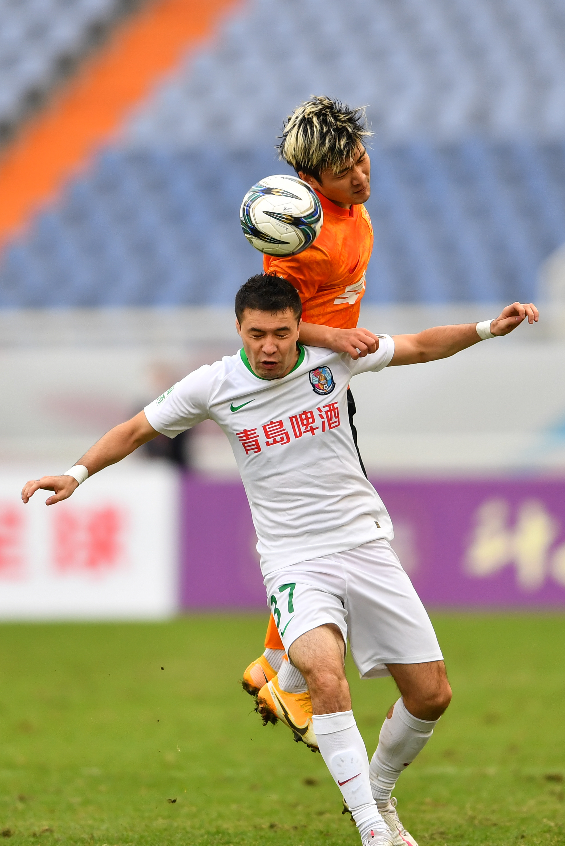 10月19日,武汉队球员赵宏略(上)与青岛队球员叶尔凡·叶孜木江在比赛