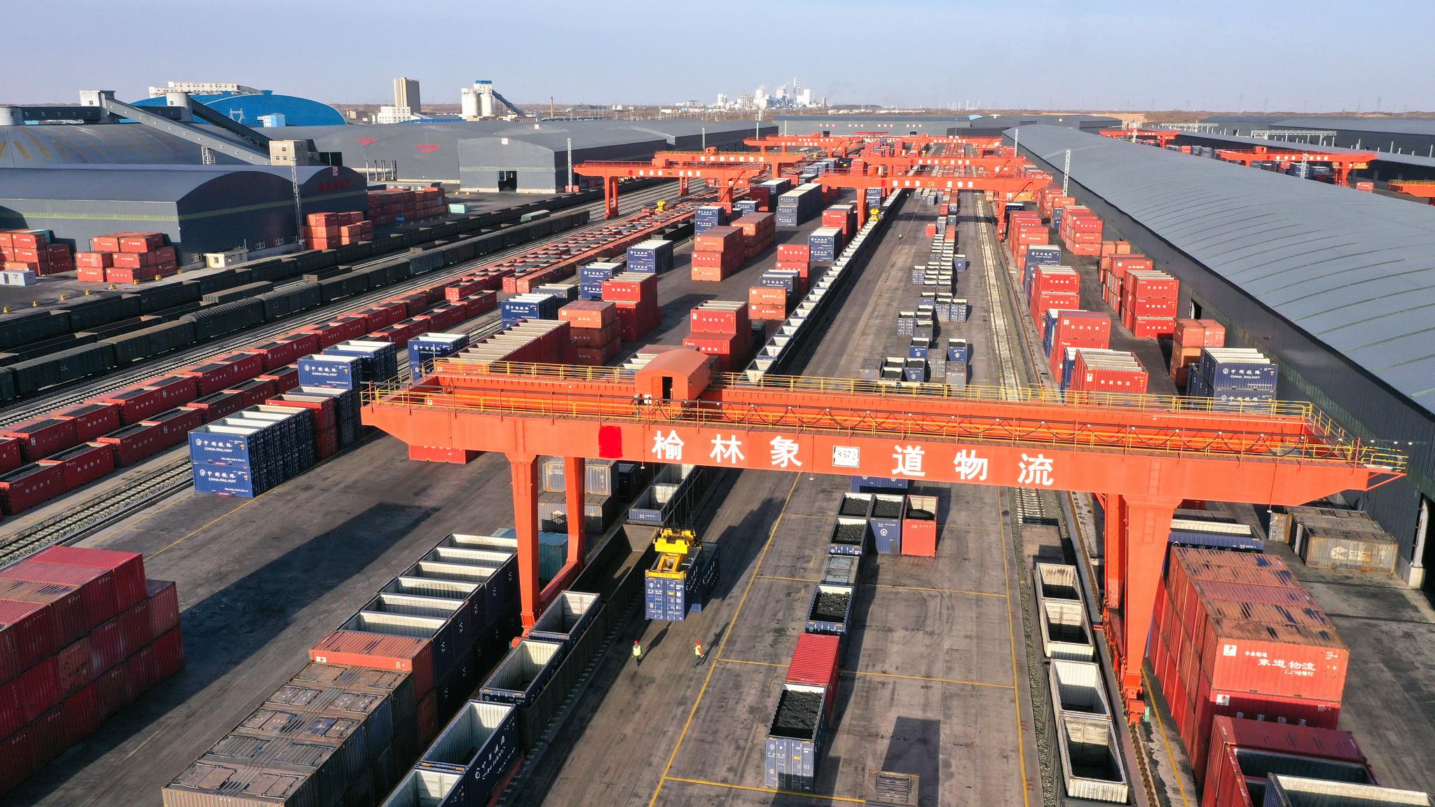 在榆林象道国际物流园集装箱装卸区,工作人员在指挥装卸外运煤炭(无人