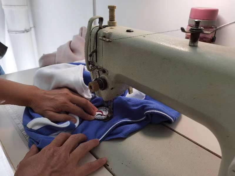 爱心便邻义务缝补葵涌志愿者为学生缝上冬装校服校徽