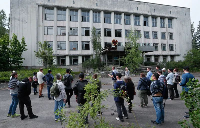 当地时间2019年6月7日，乌克兰普里皮亚季，游客在切尔诺贝利核电站事故的遗迹前打卡。（图源：东方IC）