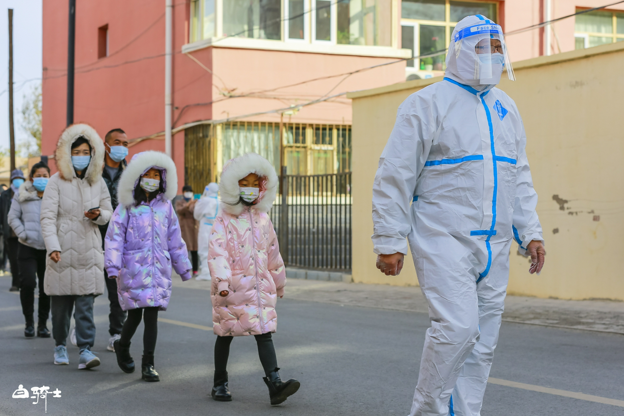 10月24日，额济纳旗教育小区，居民正在社区工作人员带领下前往核酸检测点，进行第四轮核酸检测。受访者供图/白骑士 