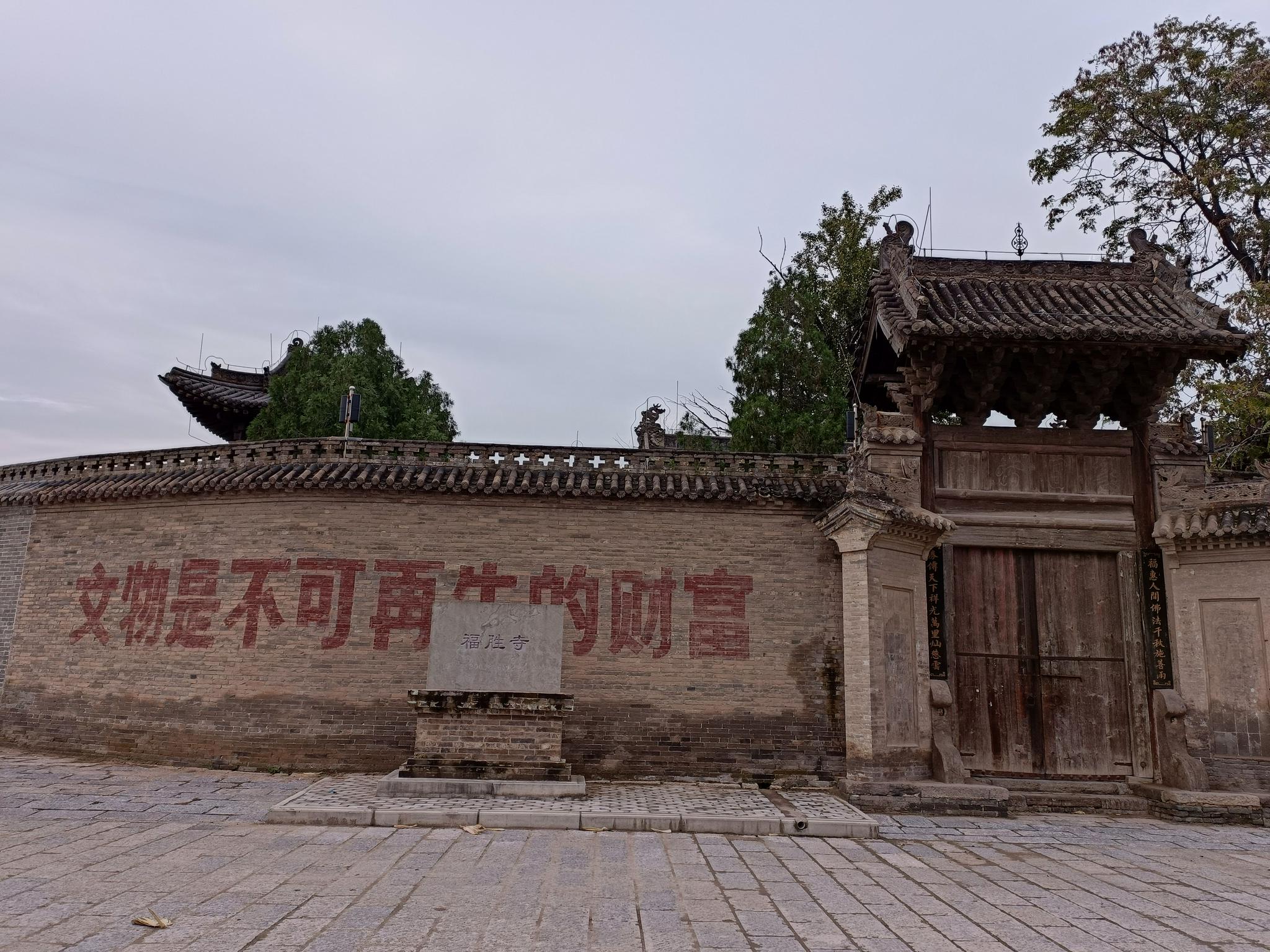 光村国保文物福胜寺的围墙上写着：文物是不可再生的财富。新京报记者 吴采倩 摄