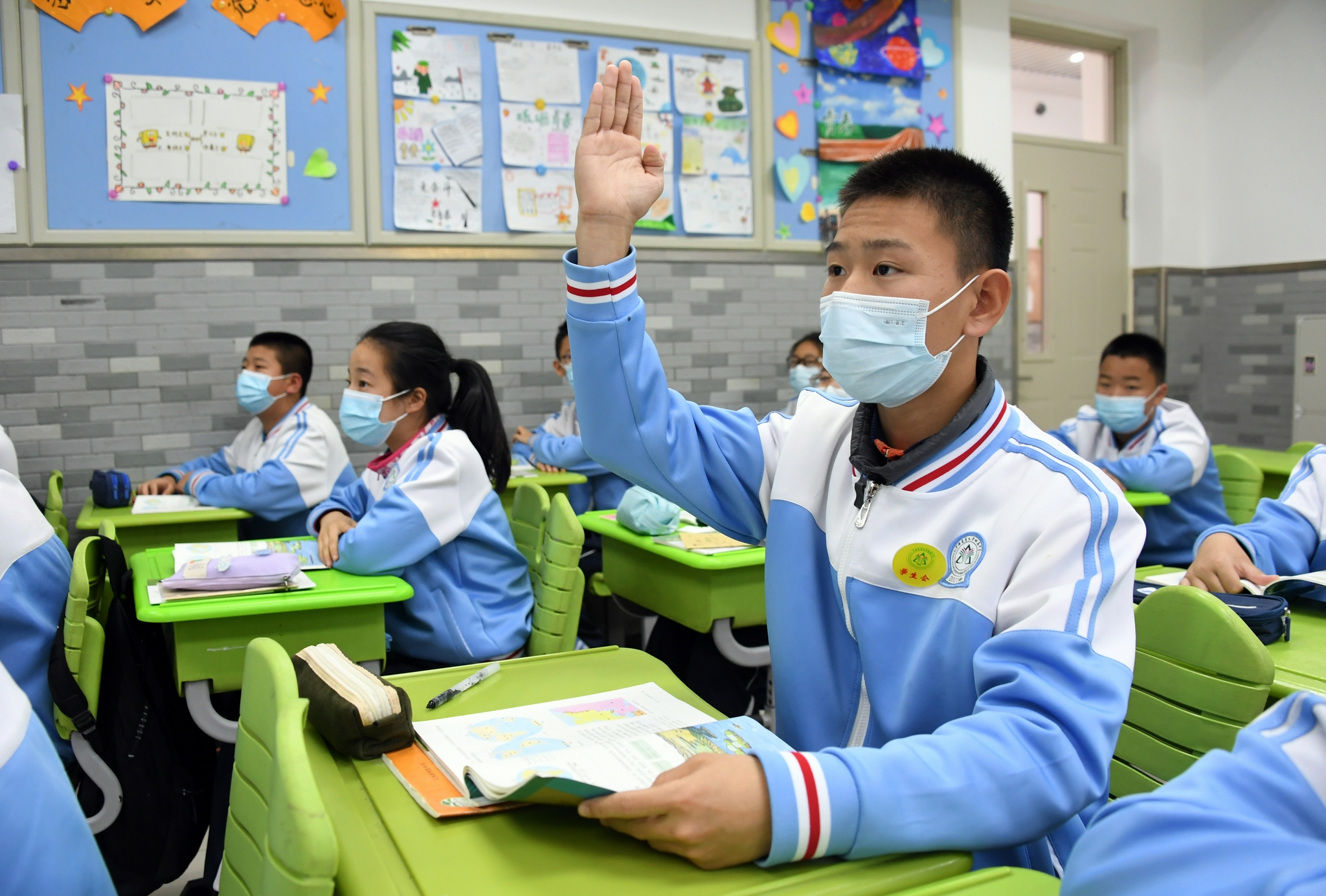 在中国农业大学附属中学初一(2)班,学生齐一麟在课上举手回答问题(10
